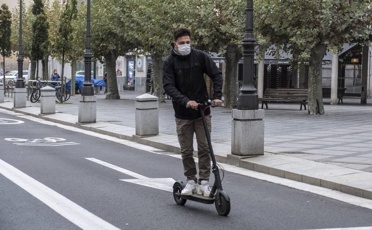 Un joven circula con su patinete por un ciclocarril a la altura de la plaza de la Rinconada.