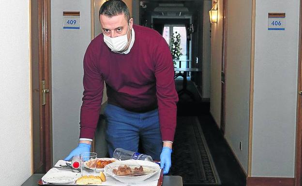 Javier Pastor, director del hotel, sube una bandeja con comida.