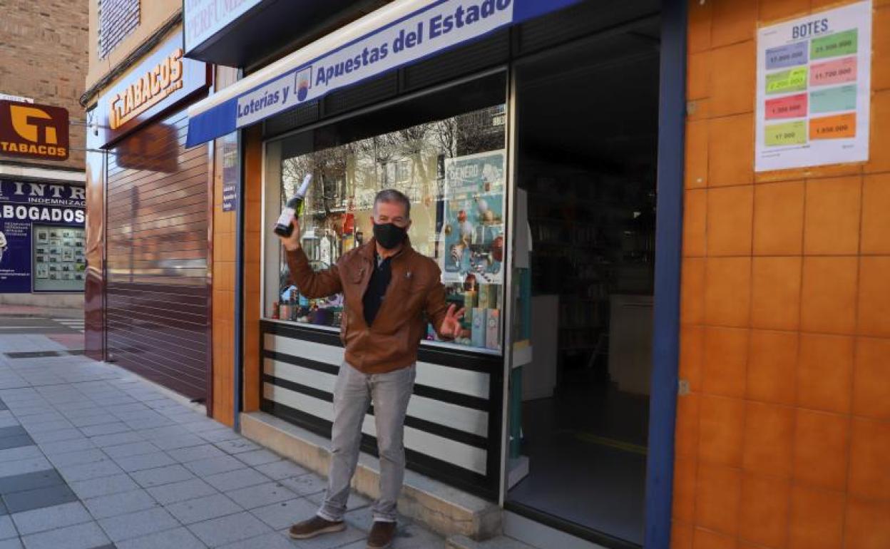 El responsable de la administración descorcha una botella el día del Sorteo del Niño. 