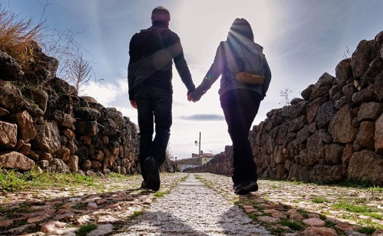 Una pareja recorre una de las típicas calles empedradas de Bonilla de la Sierra (Ávila), en una jornada de turismo rural. 