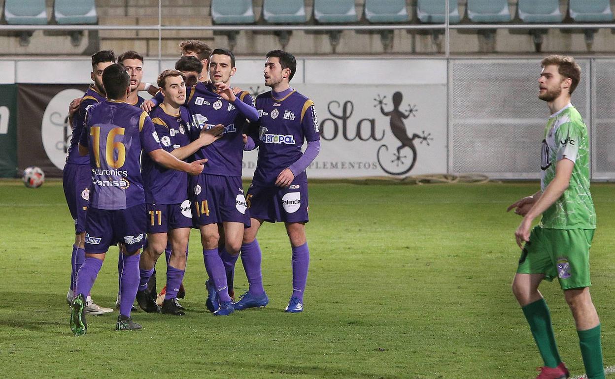 Los jugadores del Palencia Cristo celebran el único tanto del partido ante la mirada de Sierra. 