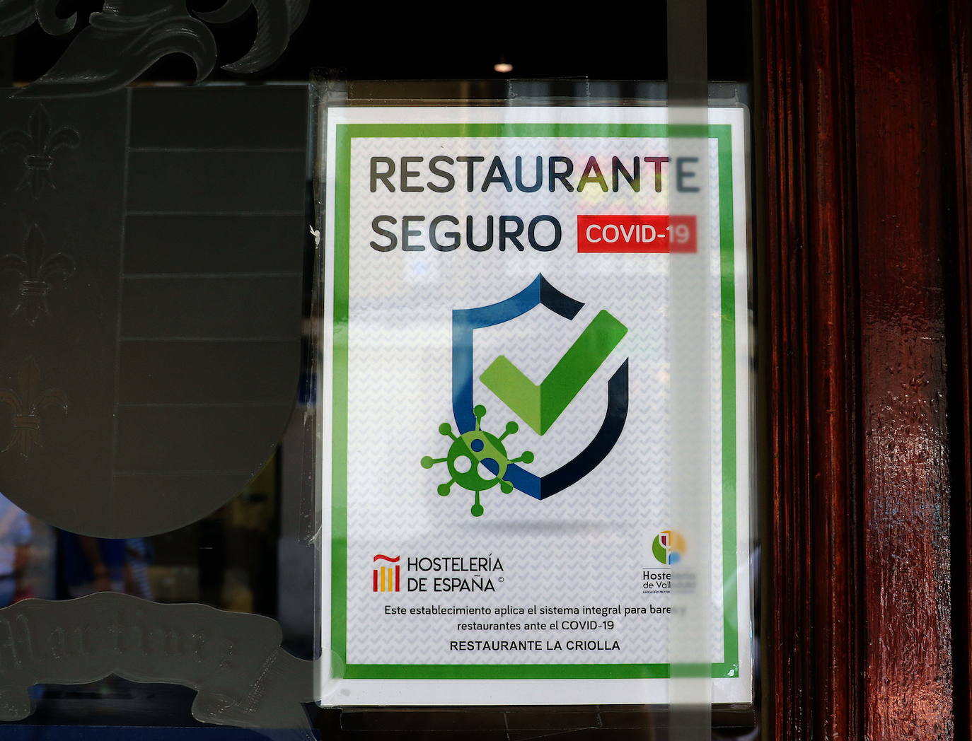 Sello de Hostelería Segura, promovido por Hostelería de España en 2020, en la puerta de un restaurante vallisoletano. 