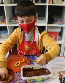 Imagen secundaria 2 - los niños elaboran sus palitos de chocolate, mientras practican inglés 