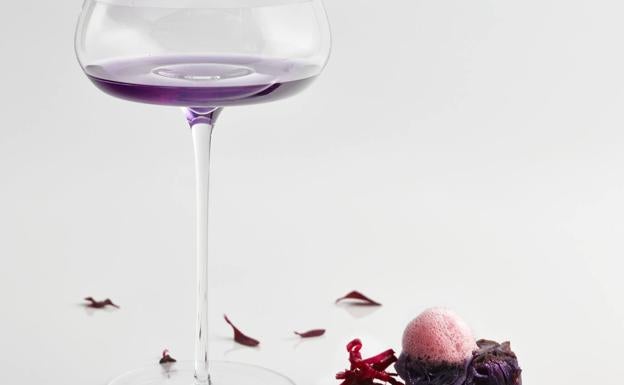 Morado-lombarda. Cóctel Purple Rain (jugo de lombarda con ron, zumo de limón y esencia de ciruela) con dadito de lombarda confitada a baja temperatura y marcada a la parrilla, con aire de hollejos tintos, violetas y demi glace de lechazo. 