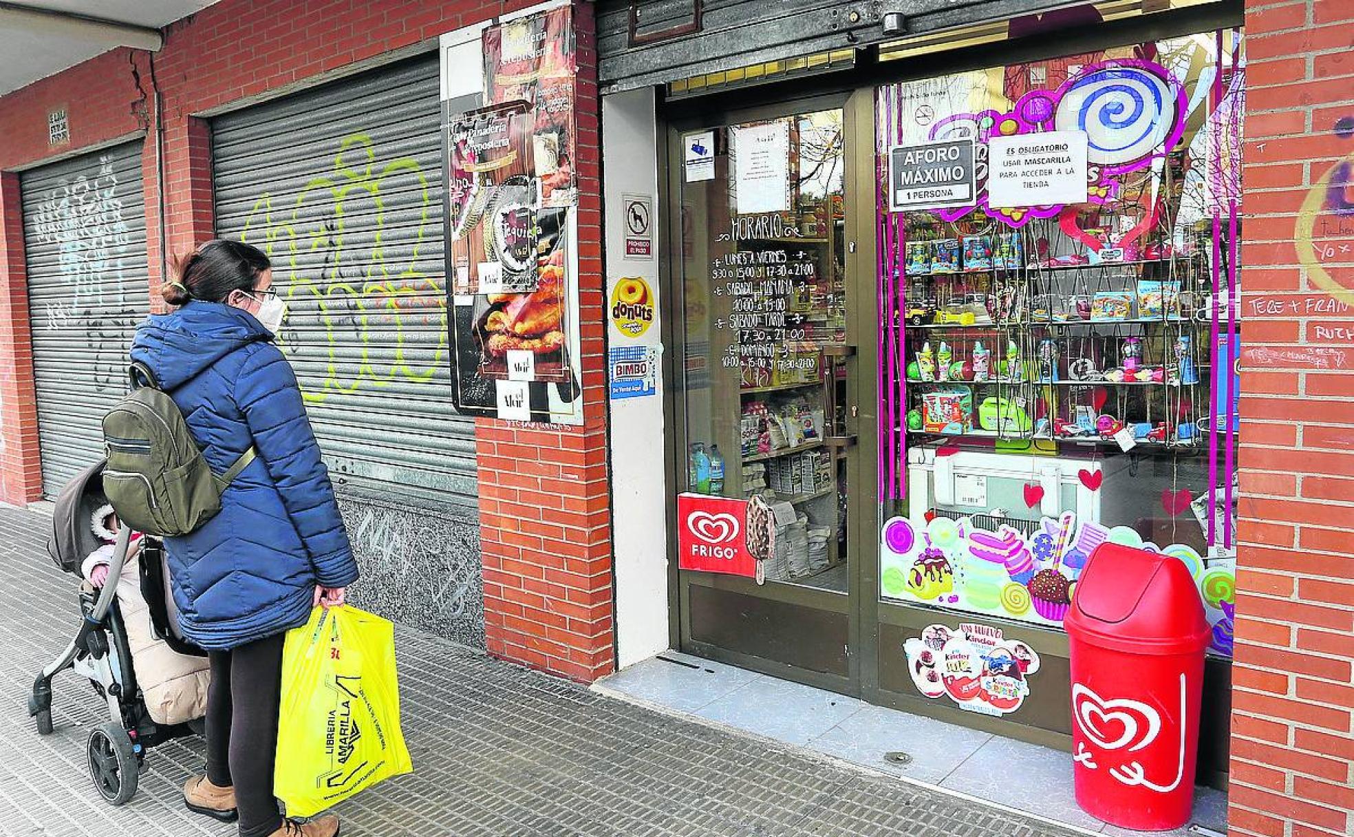 Una mujer espera para acceder a la tienda en la que se produjo el atraco.