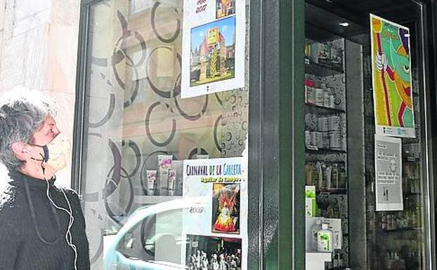 Una mujer contempla las fotografías antiguas en un escaparate.