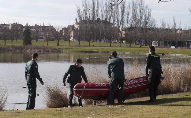 Los agentes introducen una lancha en el lago.