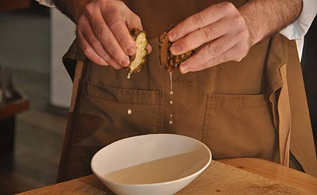 El chef exprimer una piña verde de pino piñonero. 