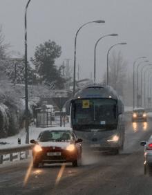Imagen secundaria 2 - Arriba, un vecino de Palazuelos retira la nieve de su coche; abajo izquierda, quitanieves en la zona de Valsaín para limpiar la carretera, y a la derecha, coches y autobuses circulan con cuidado entre Segovia y La Granja. 
