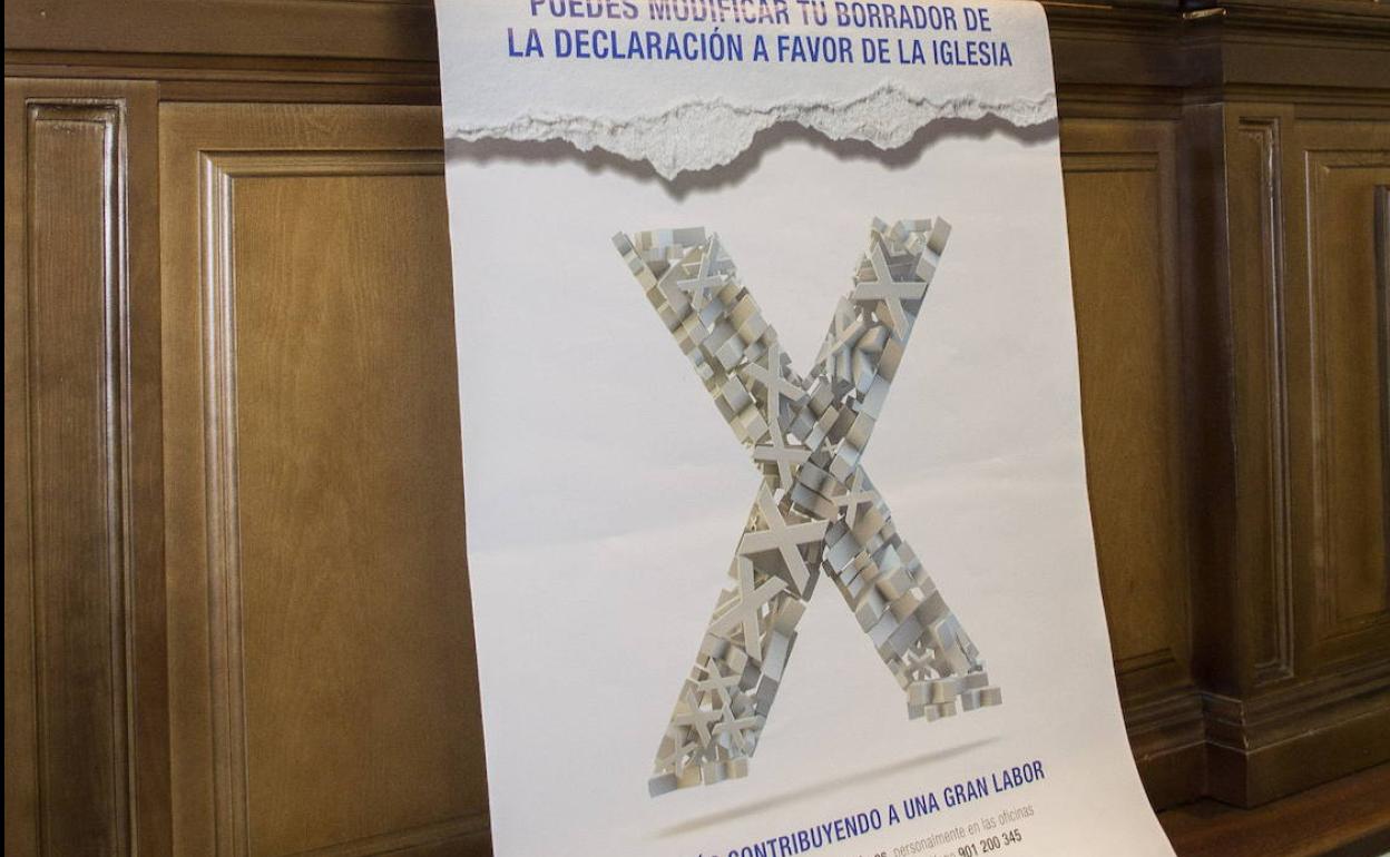 Cartel de una campaña a favor de marcar la X en la declaración de la renta. 