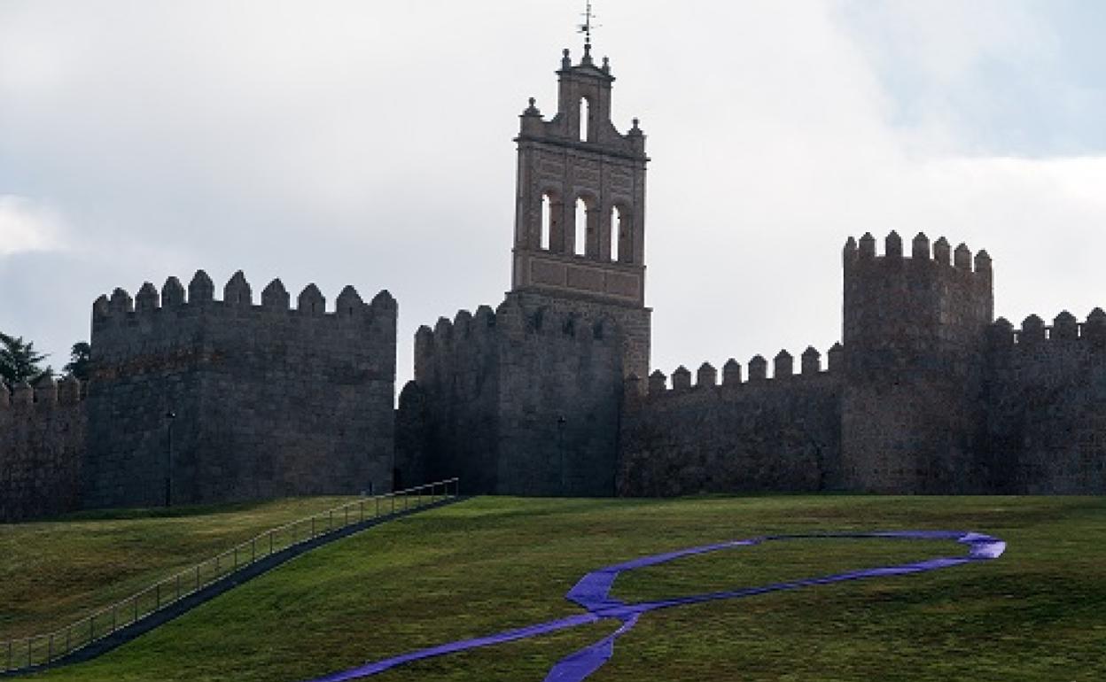 Un gran lazo morado en la explanada del lienzo norte de la muralla de Ávila, con motivo del Día Internacional contra la Violencia de Género 