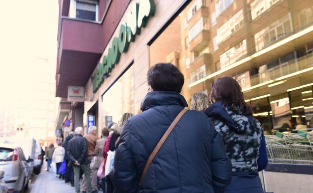 Imagen principal - Colas en el supermercado, el sábado por la mañana. En la calle Santiago comenzaban a verse las primeras mascarillas. Los comercios comenzaban a anunciar sus cierres por el inicio del estado de alarma. 