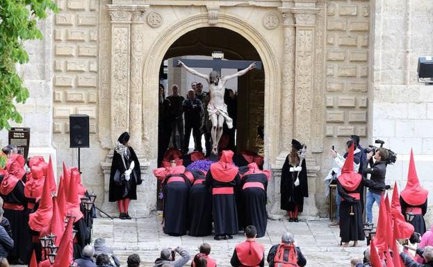 Los cofrades de la Hermandad Universitaria del Santísimo Cristo de la Luz sacando de rodillas la talla de Gregorio Fernández por la puerta del Palacio de Santa Cruz