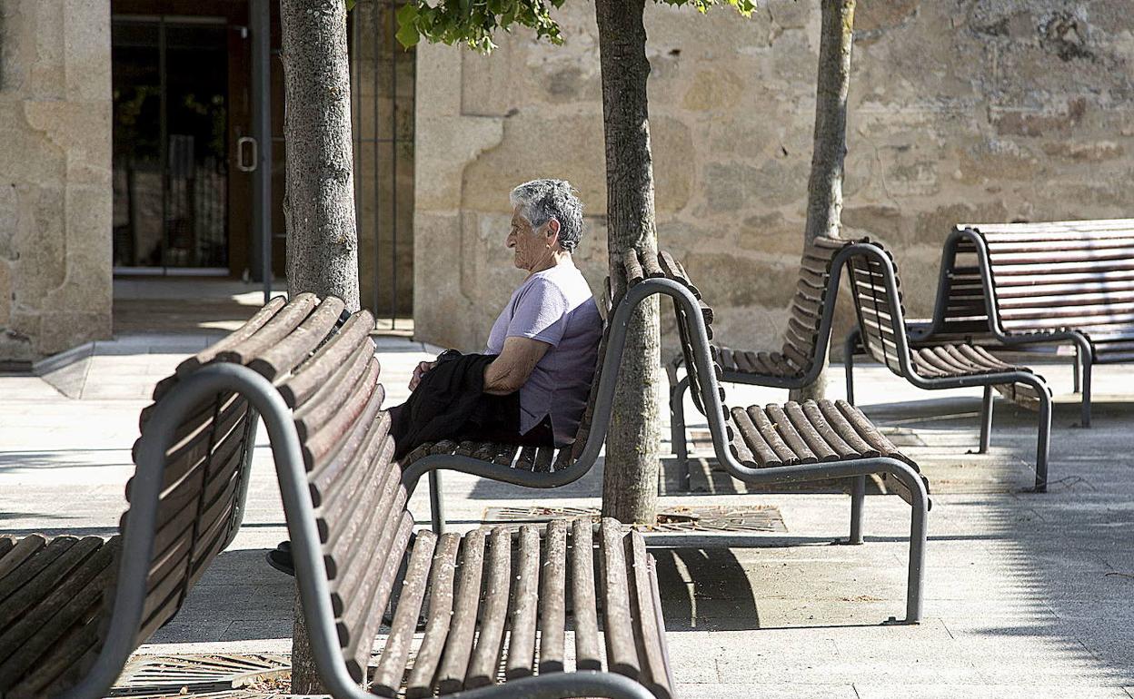 Una mujer descansa en un banco de Fermoselle, en la provincia de Zamora. 