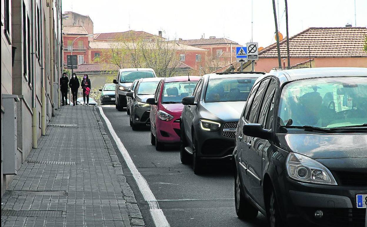 Atasco de coches con el motor en marcha a escasos metros de viviendas en la calle San Gabriel. 