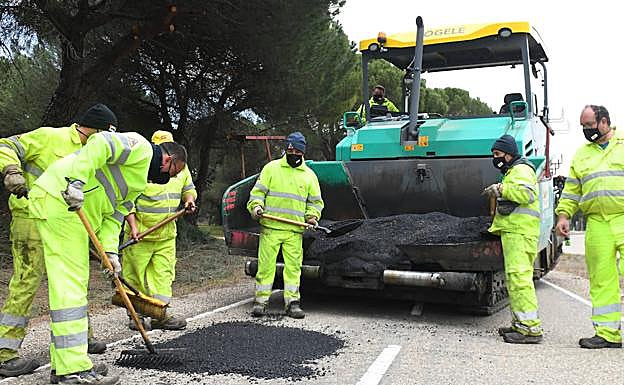 Los operarios arreglan uno de los baches en el carril-bici del Pinar de Antequera.