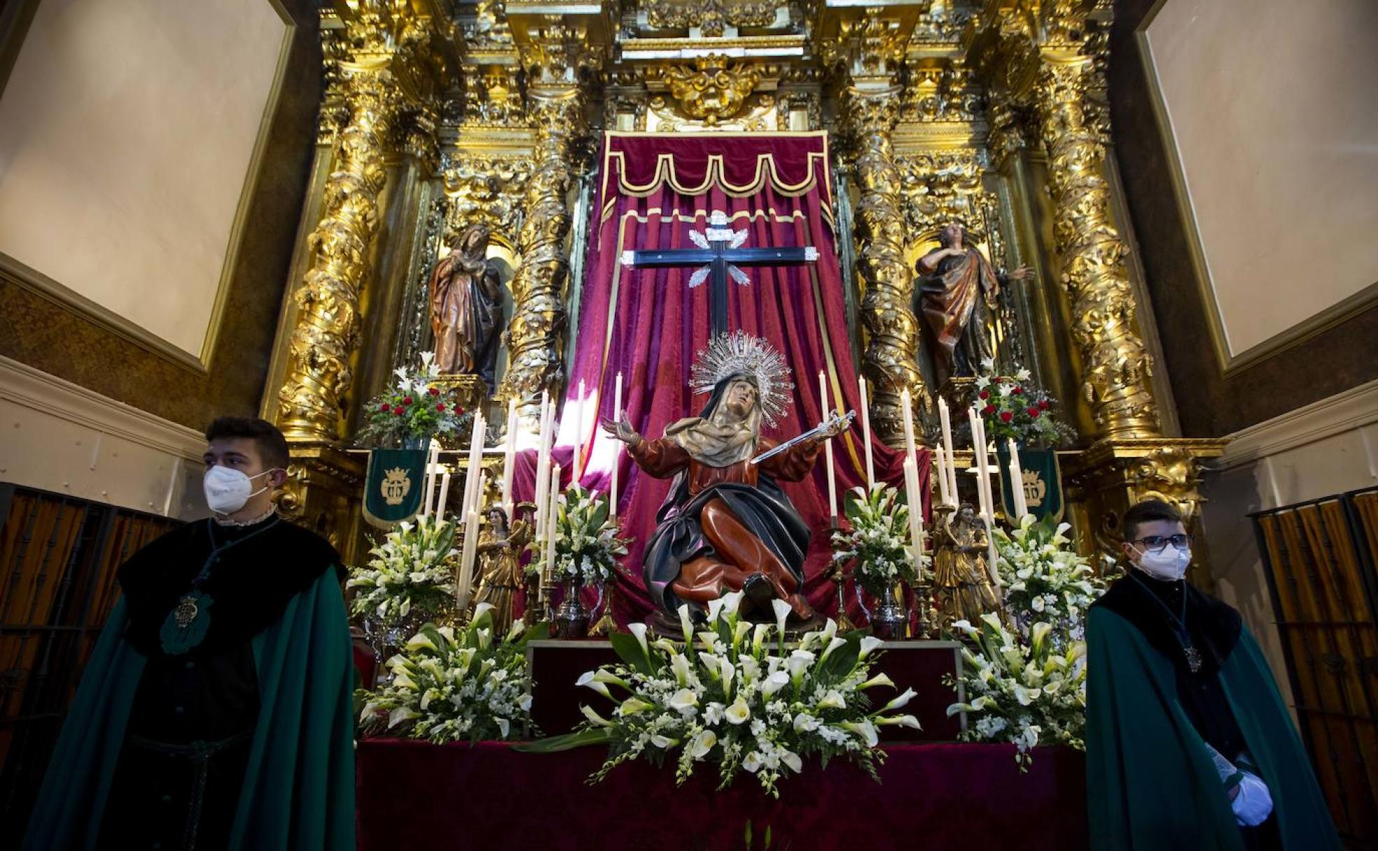 Dos cofrades, ante el altar de la Dolorosa en la iglesia de la Vera Cruz. 