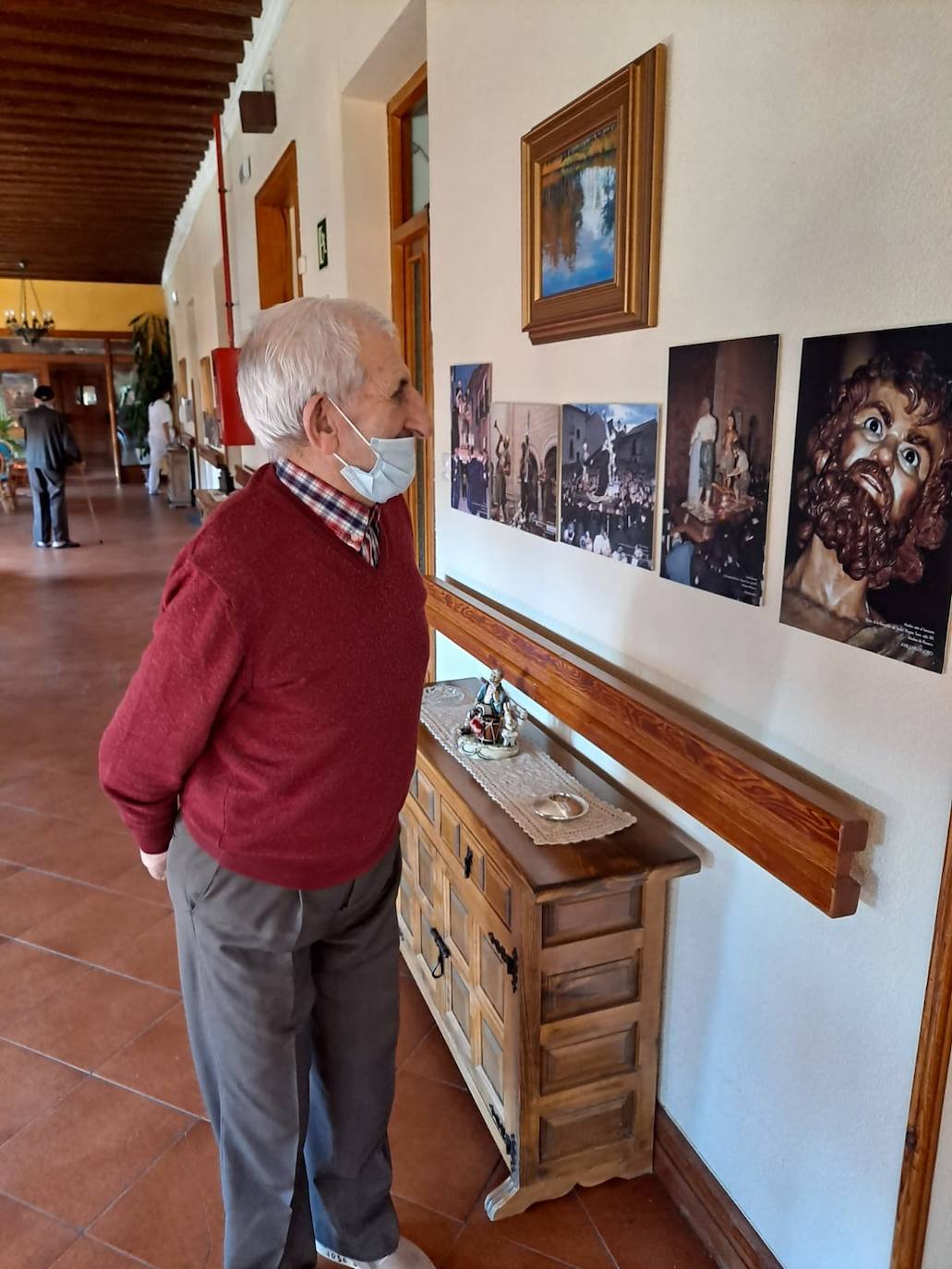 Uno de los residentes observa una de las fotografías expuestas. 