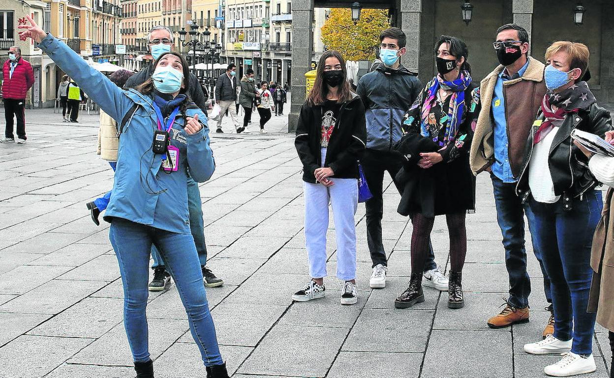 Una guía muestra el Acueducto a un grupo de turistas en el Azoguejo. 