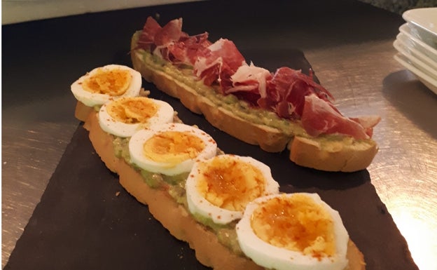 Tapas con bases de guacamole combinado con jamón serrano y huevo cocido 