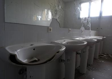 Imagen secundaria 1 - Pintadas en el comedor. Debajo, daños en los aseos y destrozos en una de las ecoterrazas.