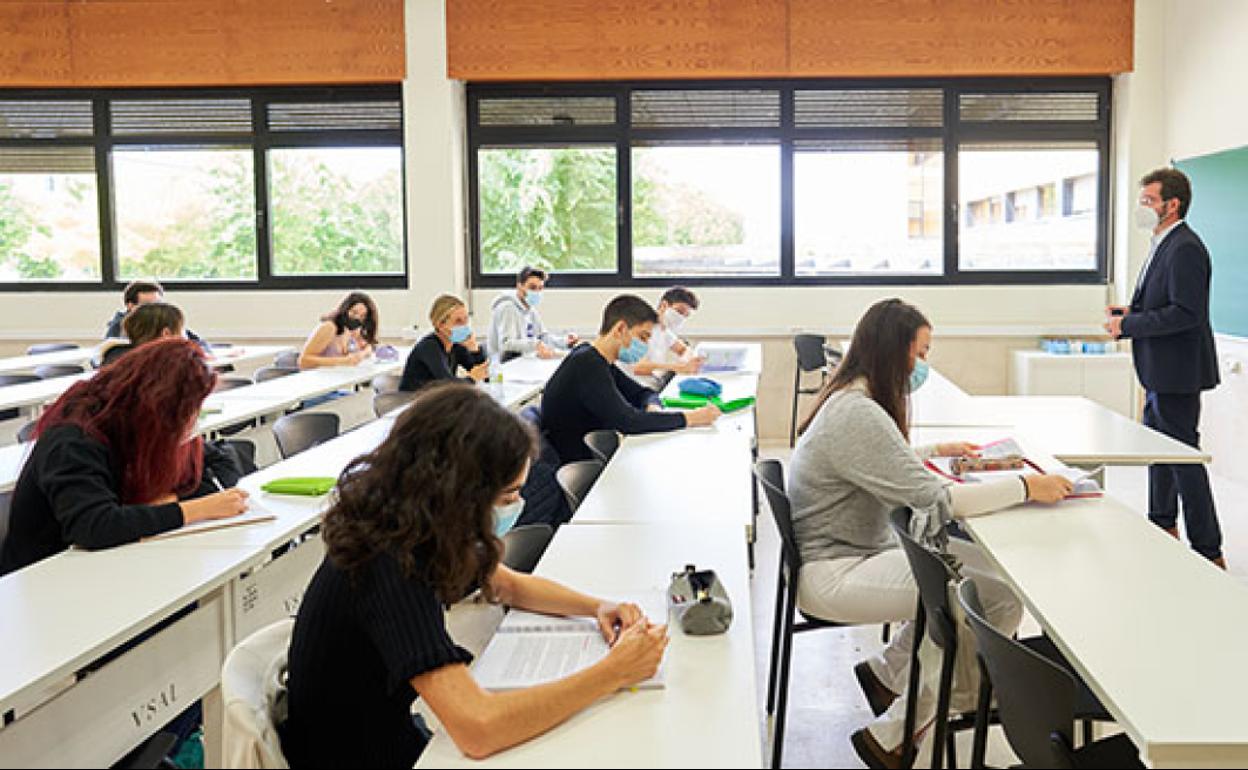 Un profesor universitario da clase en un aula.