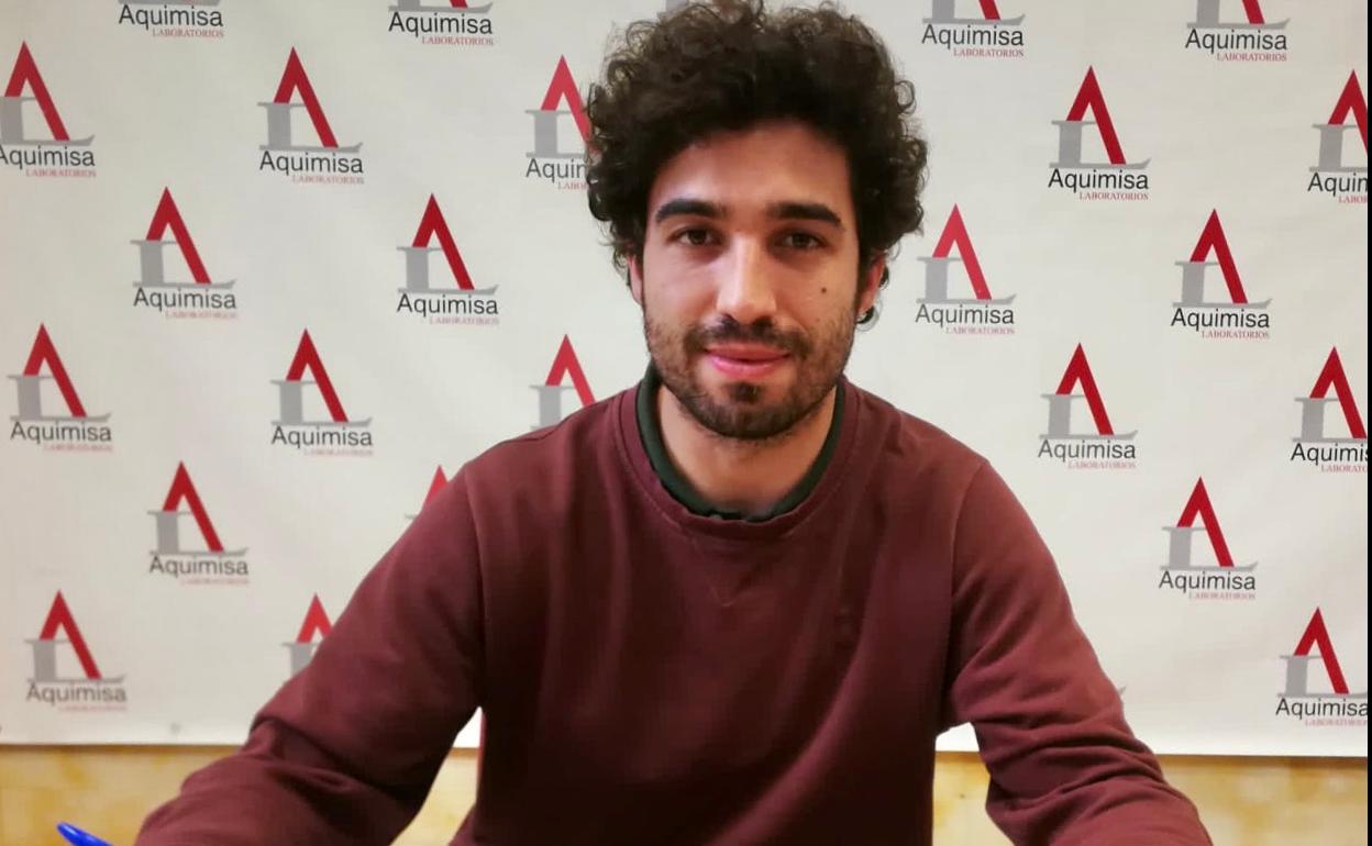 Arturo Cruz Sastre posa con una cartel con el logotipo de Aquimisa, la empresa en la que trabaja.