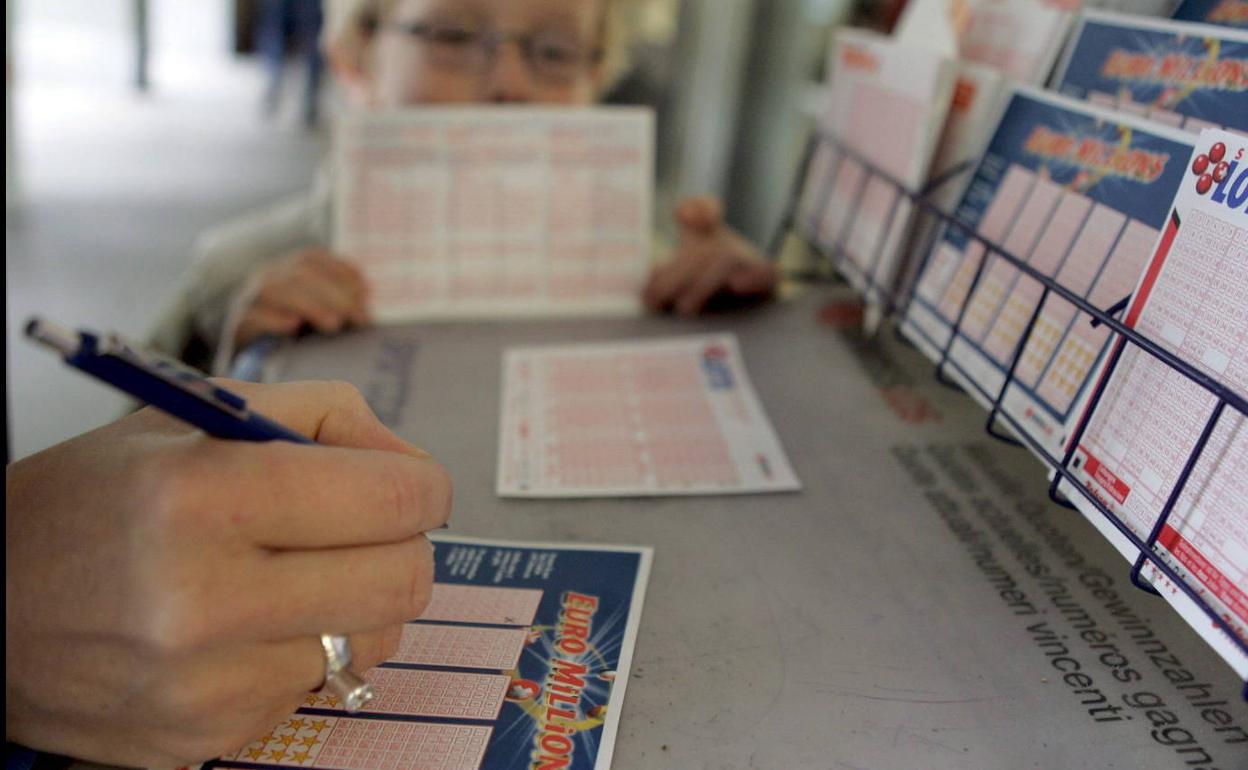 Una mujer rellena un boleto de un sorteo.