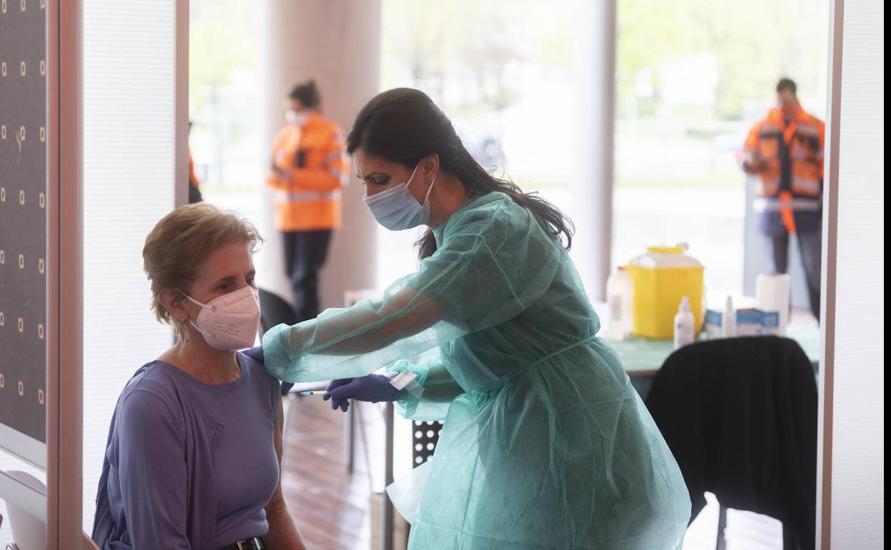 Una sanitaria vacuna a una mujer en el Centro Miguel Delibes. 