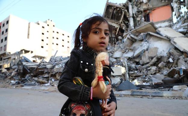 Un niña palestina pasa junto a un edificio destruido en un bombardeo.