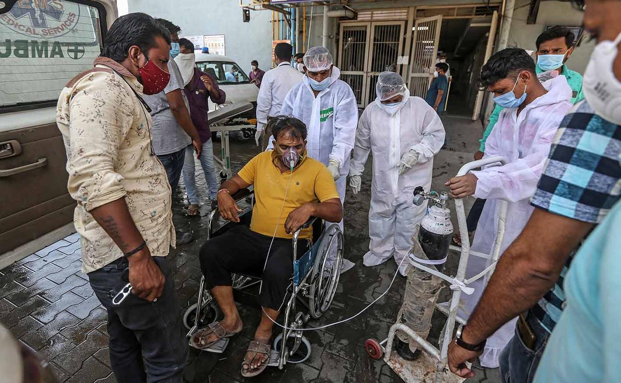 Trabajadores de un hospital indio atienden a un paciente 