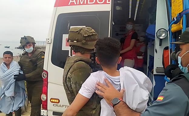 Miembros del Ejército ayudan a dos niños inmigrantes en uno de los espigones fronterizos de Ceuta este martes. 