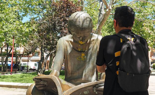 Un hombre mira las pintadas en la escultura de la plaza de las Batallas.