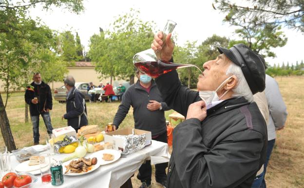 Varios hombres almnuerzan en la campa del Carmen. 