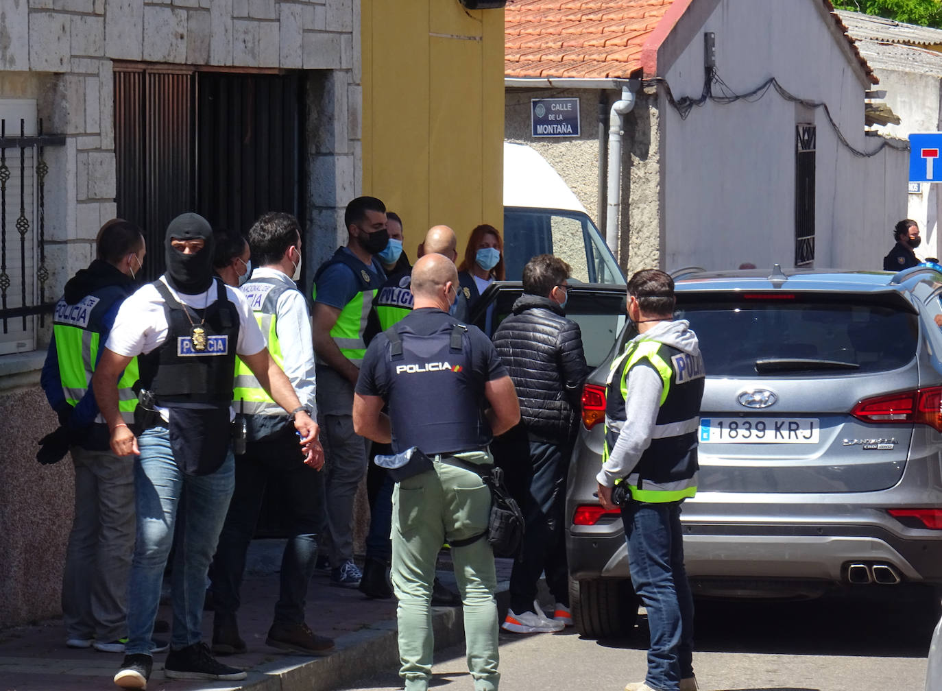 Los policías introducen al dueño del club Latino (con abrigo negro) después de registrar su casa de la calle Tierra del Pan (Barrio España). 