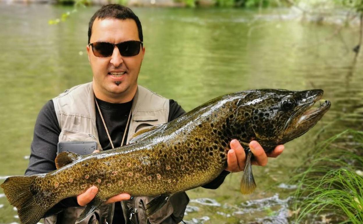 Miguel Ángel Rodríguez, 'Uru', junto con el ejemplar de trucha común de 72 centímetros.