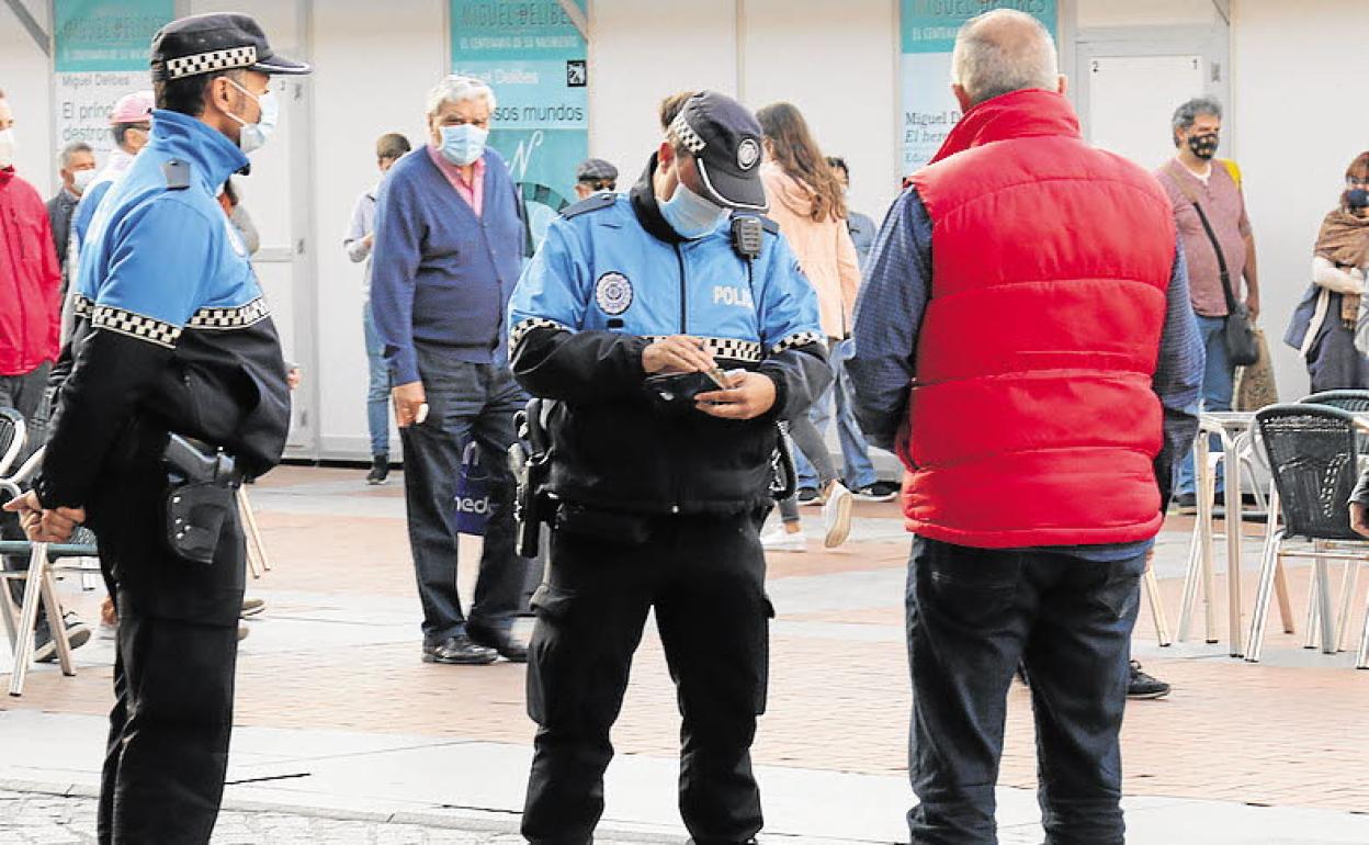 Dos agentes de la Policía Local de Valladolid redactan una sanción durante este periodo de pandemia.