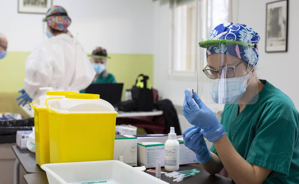 Una mujer prepara una vacuna. 