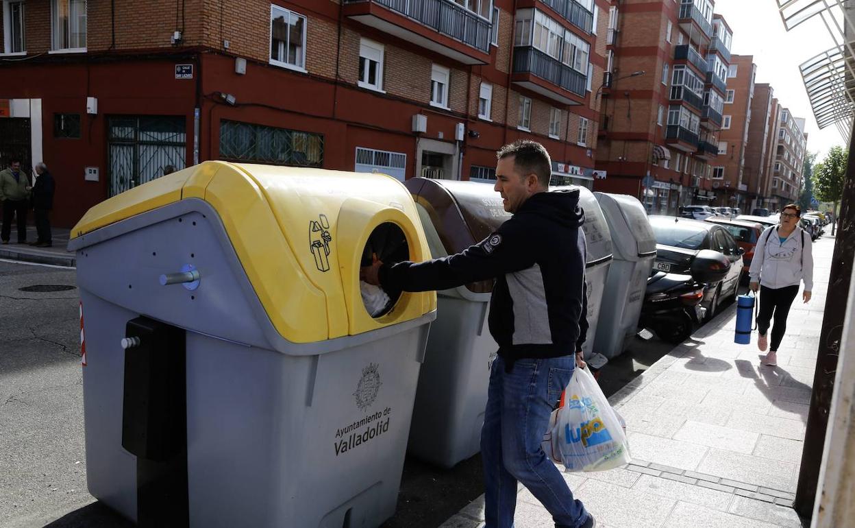 Un vecino de La Victoria, barrio que acogió una prueba piloto, deposita los residuos en el contenedor amarillo. 