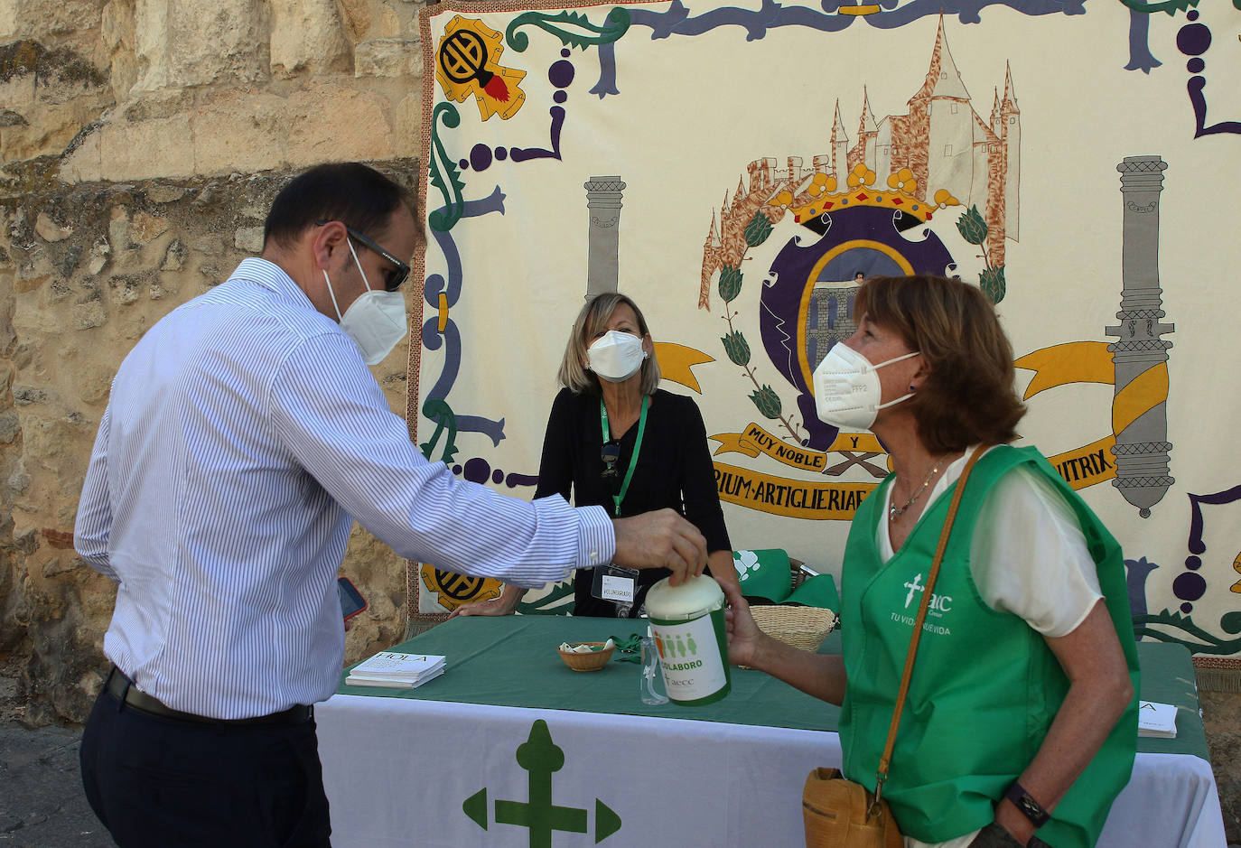 Un vecino de Segovia realiza su donativo en la mesa situada junto a la iglesia de San Clemente.