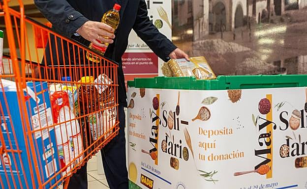 Un cliente deposita su donación de alimentos en la cmpaña de Gadis.