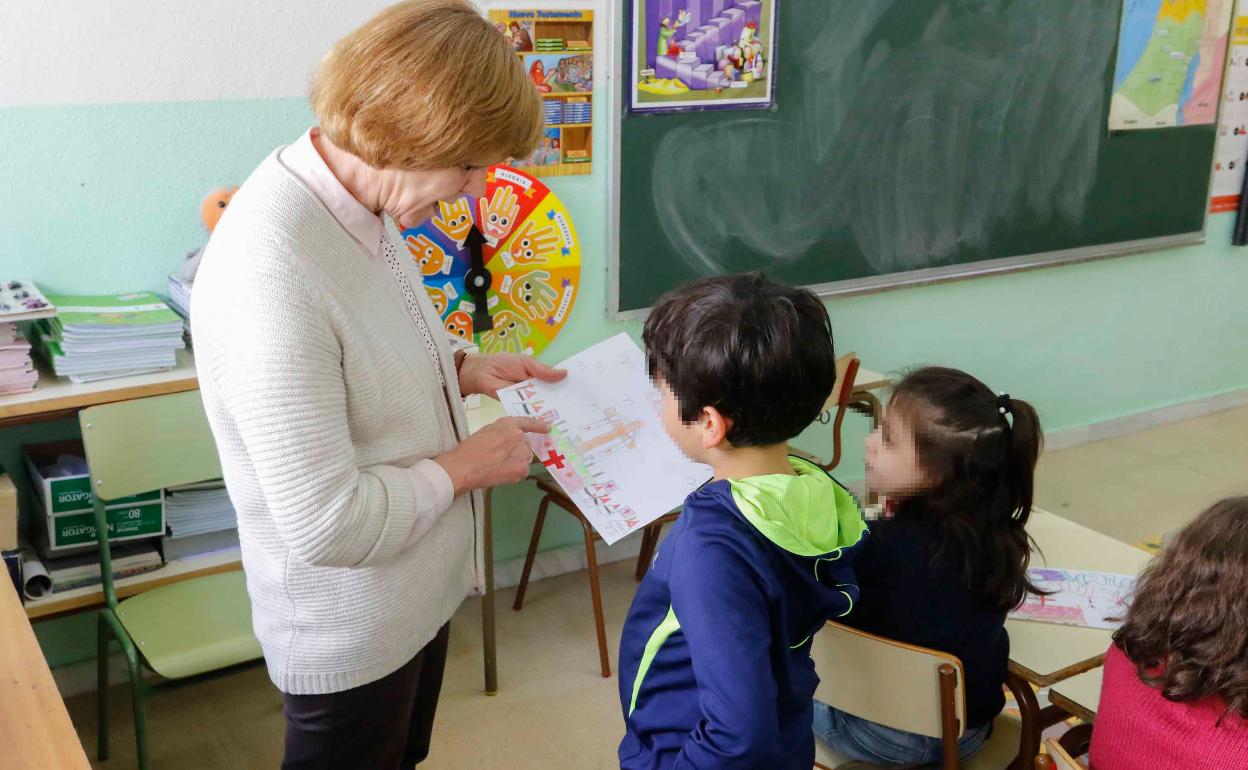 Una maestra observa el dibujo de uno de sus alumnos 