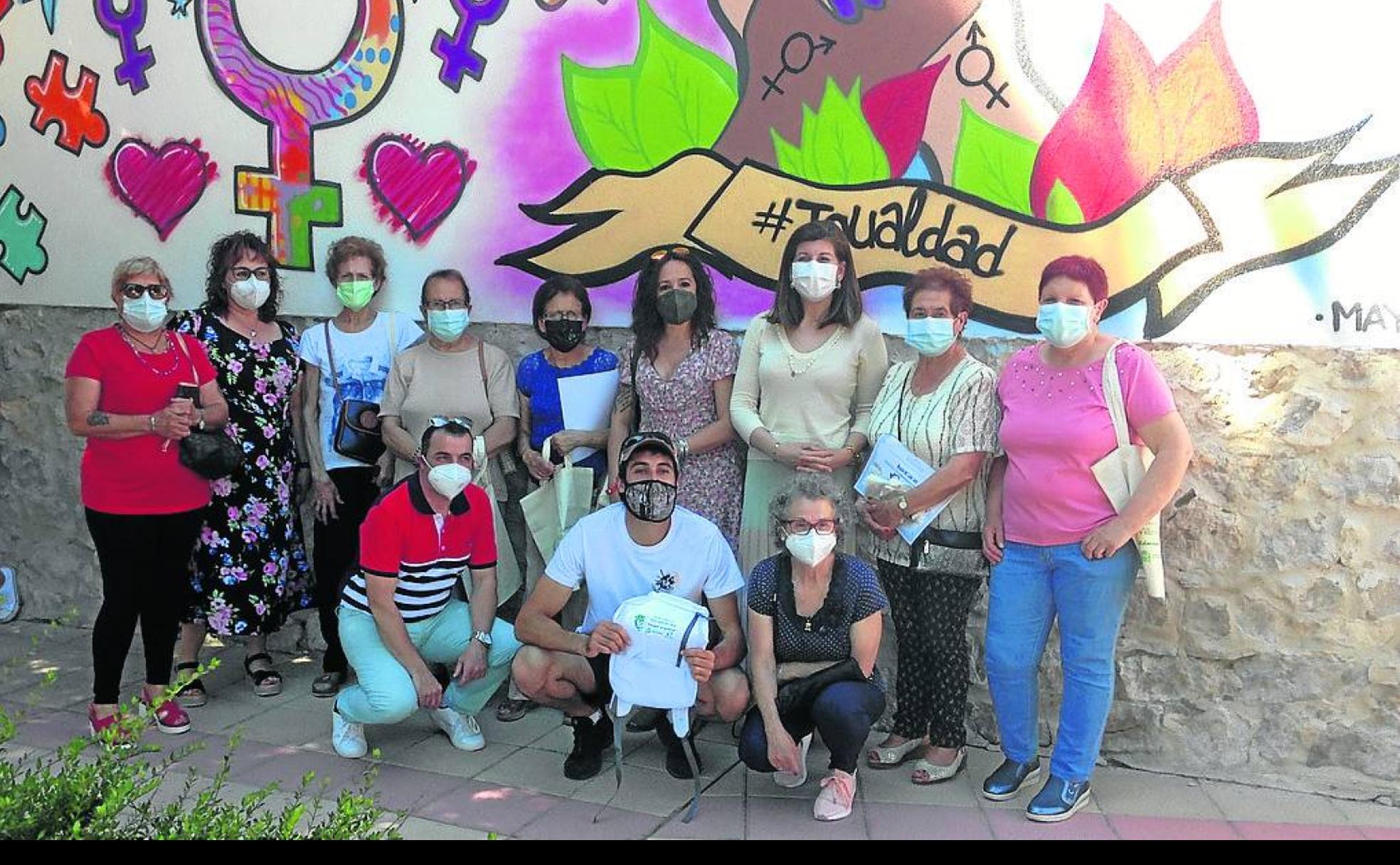 Mujeres participantes, con los promotores del taller, delante del mural, obra de Daniel Aguado. 