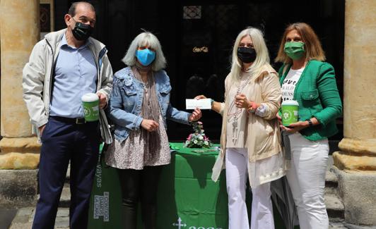 Eva Picado entregando el cheque a Inmaculada Rodríguez en presencia de dos voluntarios.