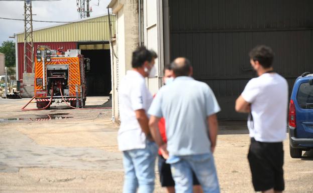 Compañeros de la víctima y vecinos del pueblo, este lunes por la mañana frente a la fábrica.