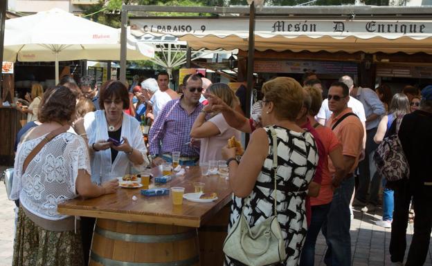 Clientes de la Feria de Día disfrutan de unas tapas en las casetas hosteleras.