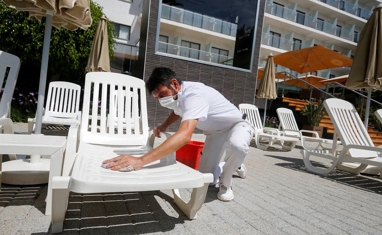 Un empleado de un hotel de Mallorca desinfecta una hamaca en una imagen de archivo.