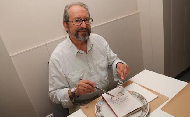 El doctor Fernández-Merino posa con su libro en un restaurante.