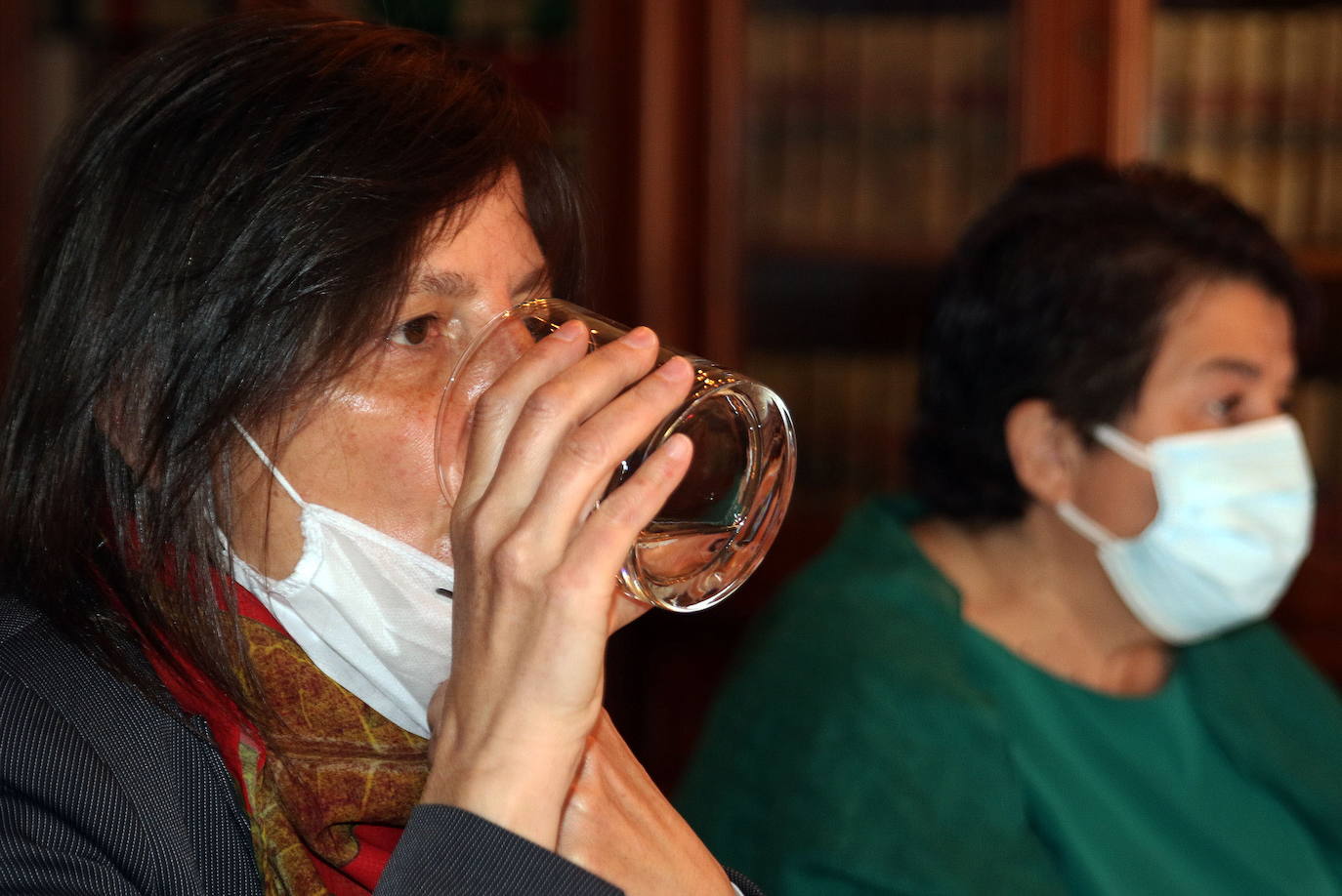 Gina Aguiar bebe agua durante una rueda de prensa, con la alcaldesa Clara Luquero, al fondo.