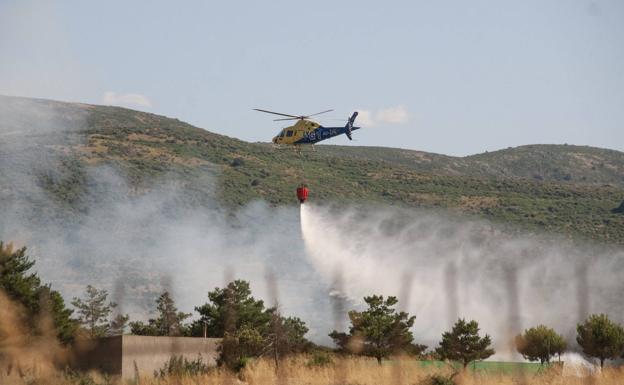 Un helicóptero suelta agua para extinguir el incendio de este jueves en Basardilla. 